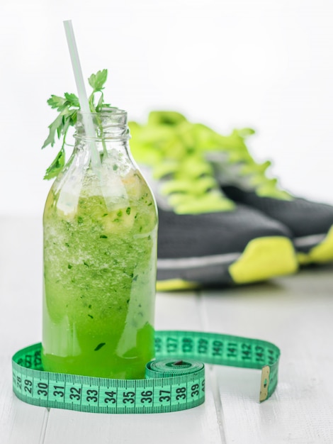 Meetlint en een fles komkommer smoothie met sneakers