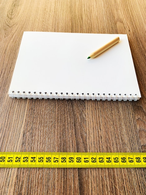 Meetlint op houten tafel met boek agenda kladblok