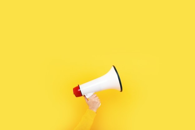 Megaphone in hand on a yellow background