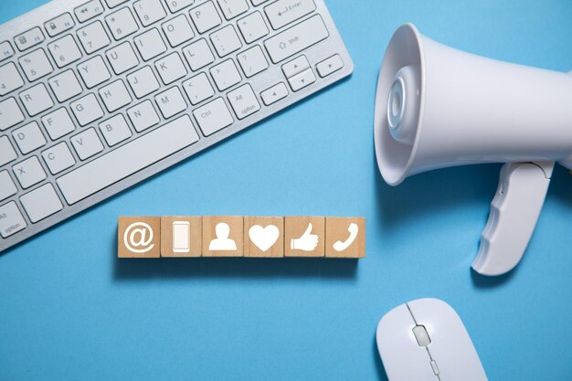 Megaphone with wooden cubes on the blue background Social Media