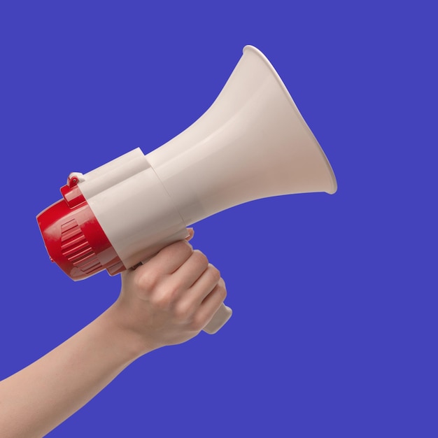 Photo megaphone in woman hands on a blue background