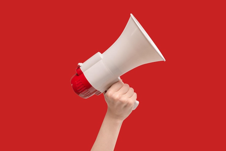 Photo megaphone in woman hands on a red background