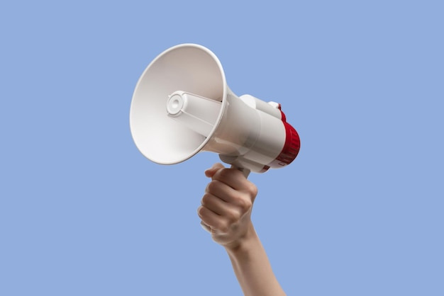 Megaphone in woman hands on a white background