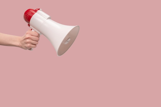 Megaphone in woman hands on a white background