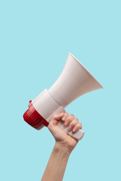 Megaphone in woman hands on a white background