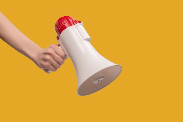 Megaphone in woman hands on a white background