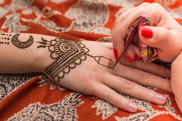 Foto mehndi-verf meester aan de hand van de vrouw