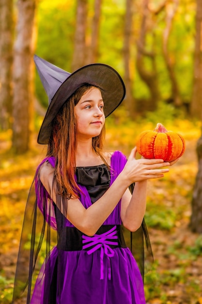 Meisje 11 jaar oud tegen de achtergrond van de herfstnatuur. Klein meisje in Halloween kostuum, herfst.