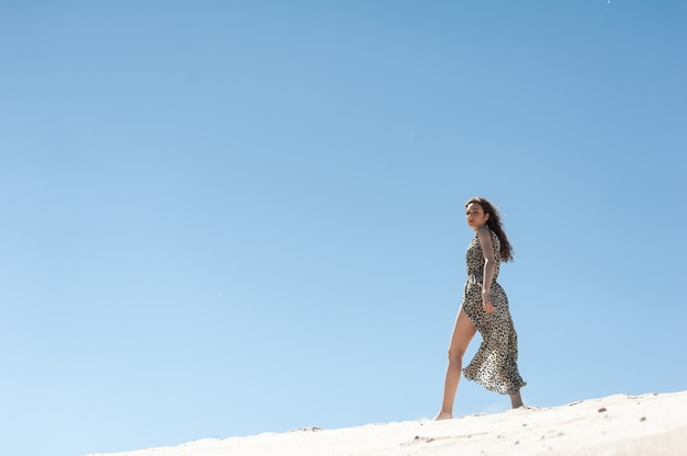 Meisje aan zee Aantrekkelijke jonge vrouw in tuniek op het strand