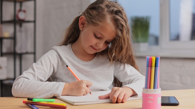 Meisje afbeeldingen tekenen met viltstift op papier album.