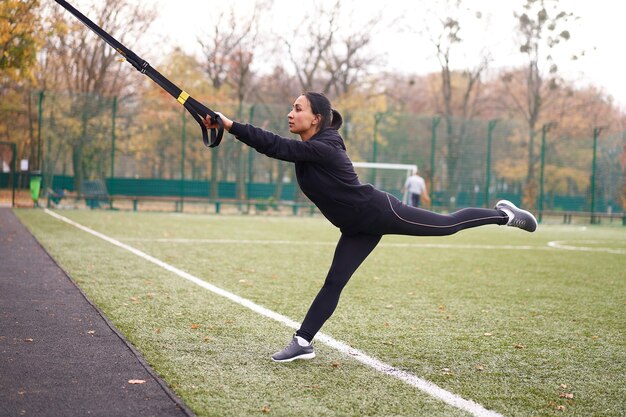 Meisje atleet training met behulp van trx op sportground