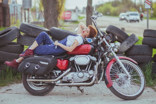 Meisje automonteur ligt op een motorfiets