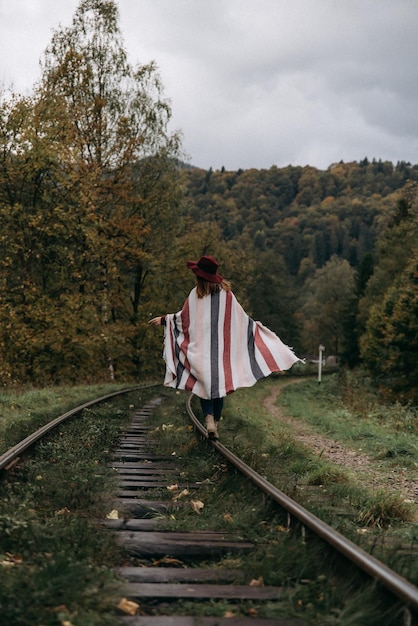 Meisje balancerend op treinrail Aantrekkelijke jonge vrouw die buiten loopt