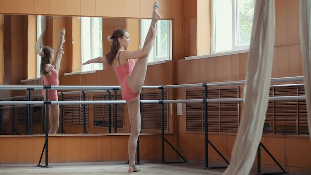 Meisje balletdanser opleiding in spiegelkamer - roze pak, groothoek
