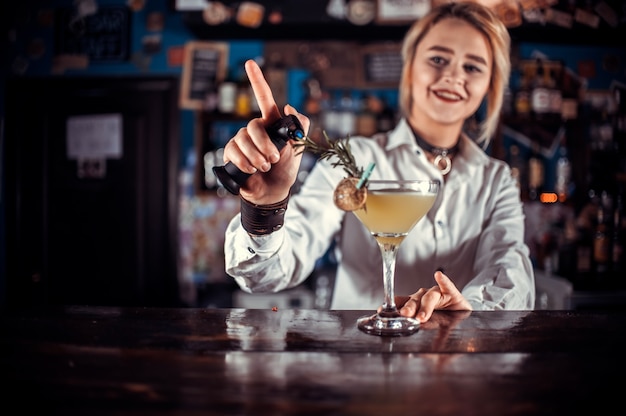 Meisje barman formuleert een cocktail in de gelagkamer