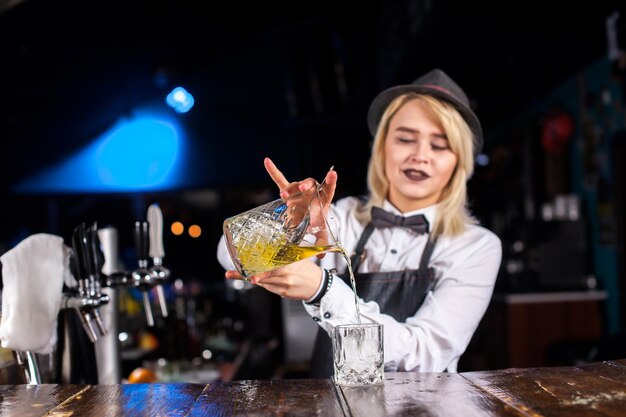 Meisje barman verzint een cocktail op de pothouse