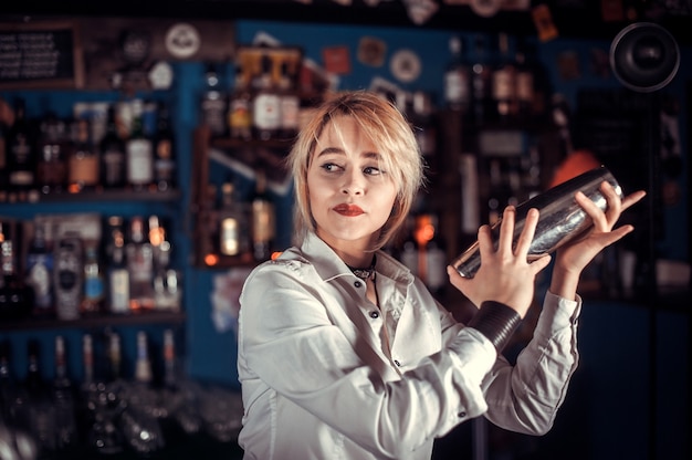 Meisje barmeisje verzint een cocktail in de brasserie