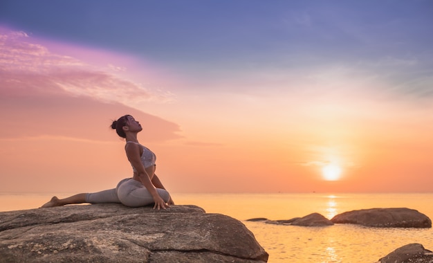 Meisje beoefenen van yoga op een rots