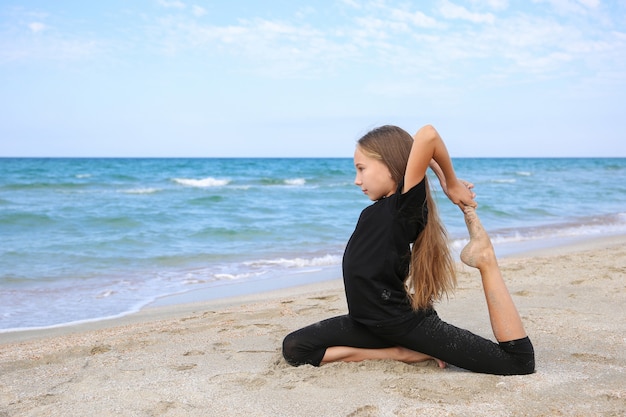 Meisje beoefenen van yoga op het strand.