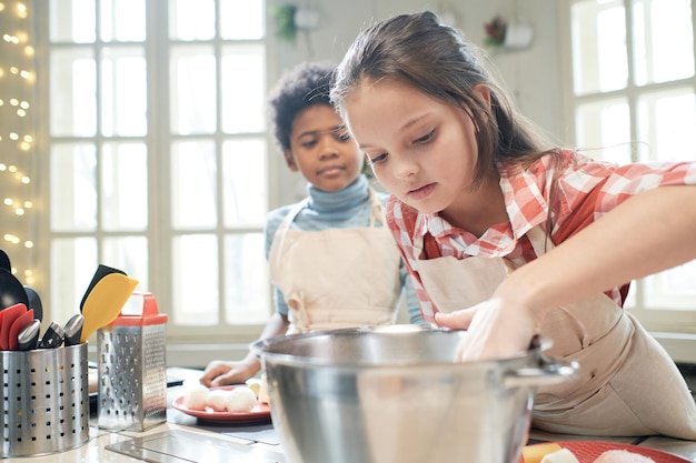 Meisje bereidt het deeg voor op cake