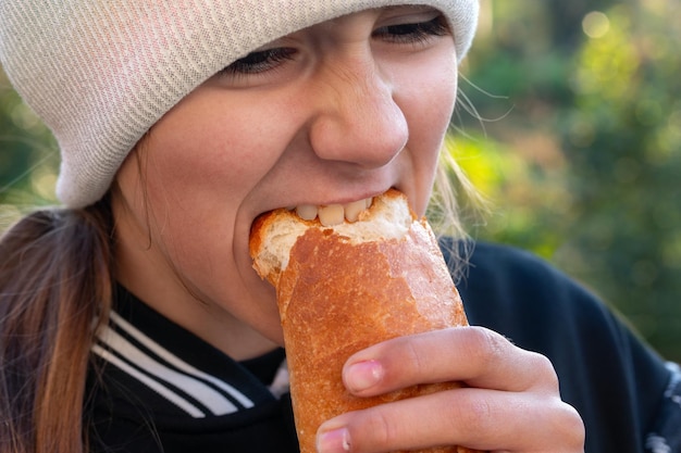 meisje bijt een stuk brood buiten in het dorp af