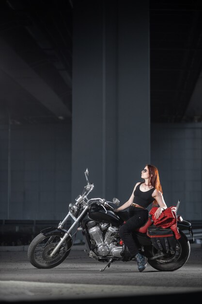 Meisje biker seksueel poseren op motorfiets 's nachts stad