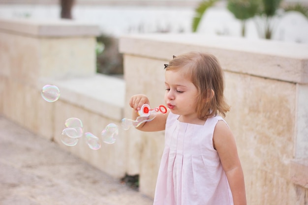 Meisje blaast bubbels met een toverstok.