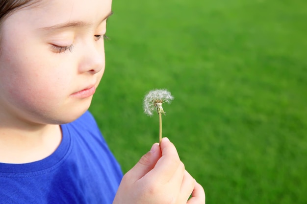 Meisje blaast paardebloem