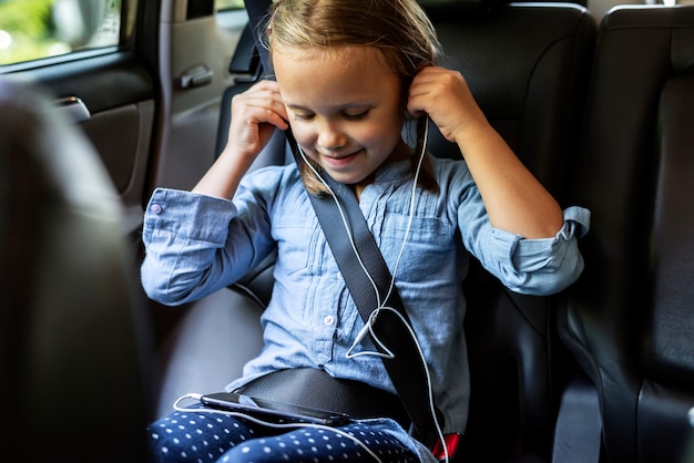 Meisje dat aan muziek in de auto luistert