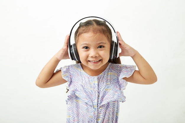 Meisje dat aan muziek op hoofdtelefoons luistert