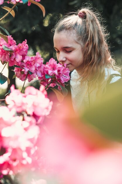 Foto meisje dat bloemen ruikt.