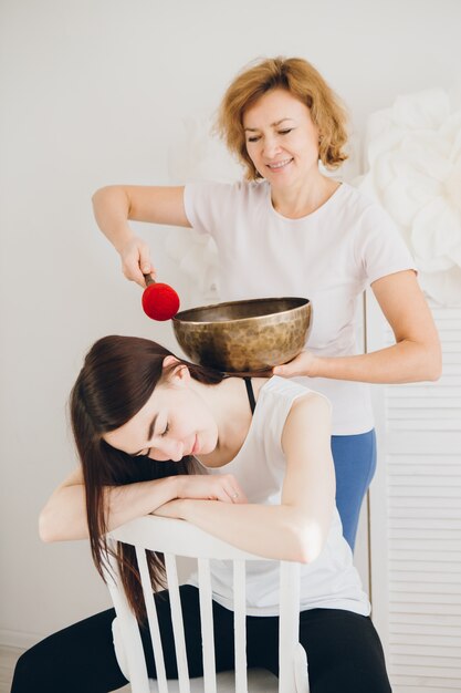 Meisje dat de zingende kommen van de massagetherapie in het Kuuroord doet