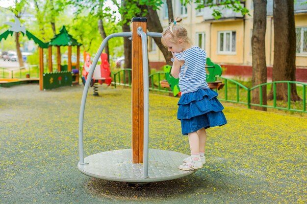 Meisje dat door spinning in speelplaats te draaien bevindt zich