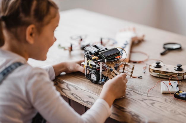 Foto meisje dat een elektrisch apparaat bekijkt