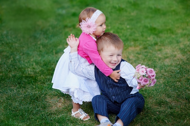 Meisje dat een jongen met een boeket van bloemen in park koestert