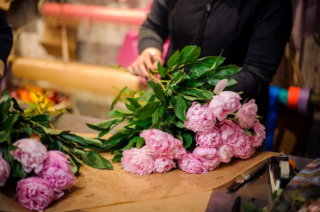 Meisje dat een mooi boeket van roze kleurenpioenen houdt