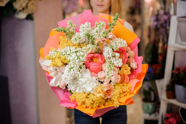 Meisje dat een mooi boeket van witte seringen en rozen houdt