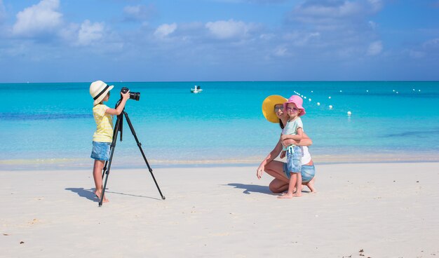 Meisje dat foto van haar moeder en zus maakt op het strand