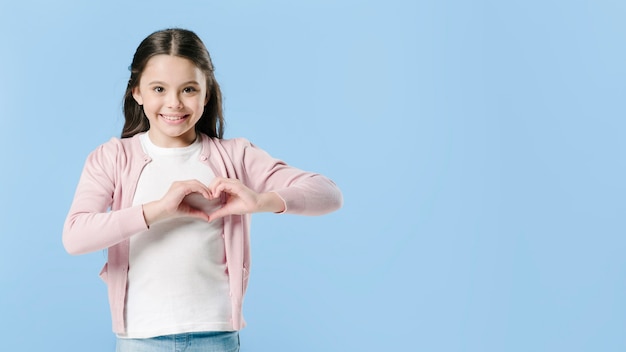 Foto meisje dat hartteken in studio toont