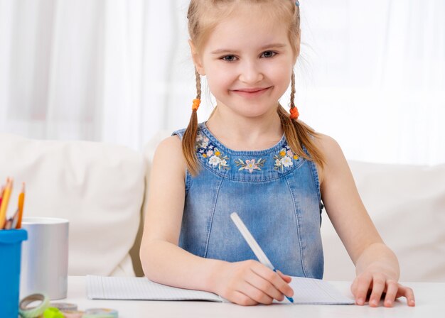 Meisje dat huiswerk doet bij bureau