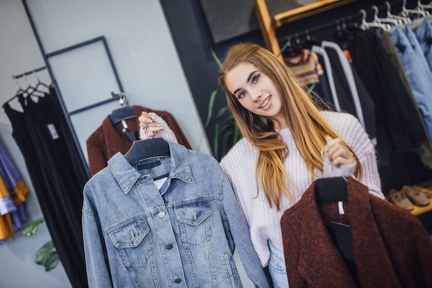 Meisje dat kleren in de winkel kiest