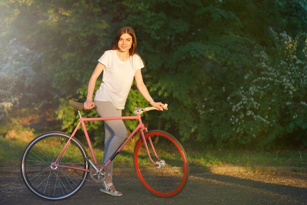 Meisje dat met Fiets op de Zonsondergang loopt