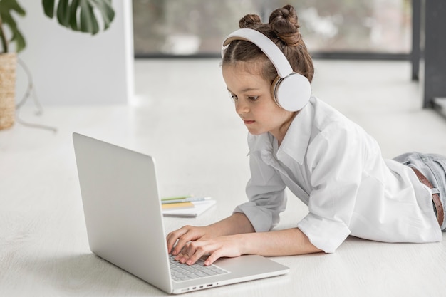 Meisje dat met hoofdtelefoons aan haar leraar luistert