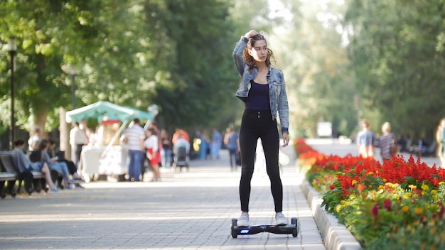 Meisje dat op een gyro in het park rijdt en naar de zijkant kijkt, maakt haar haar recht