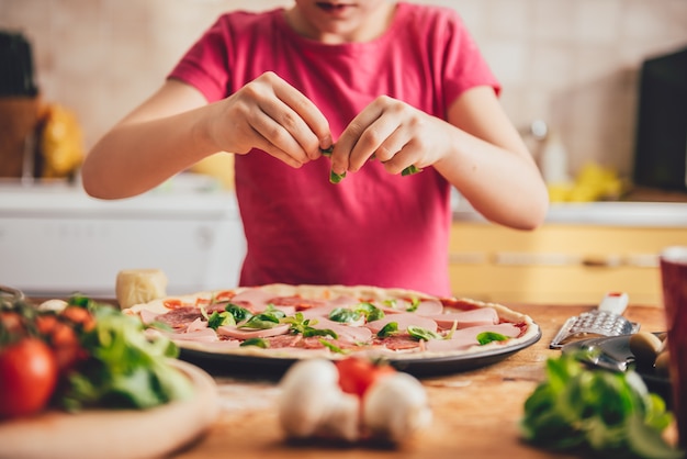 Meisje dat pizza voorbereidt