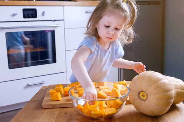 Meisje dat pompoen in een kom zet