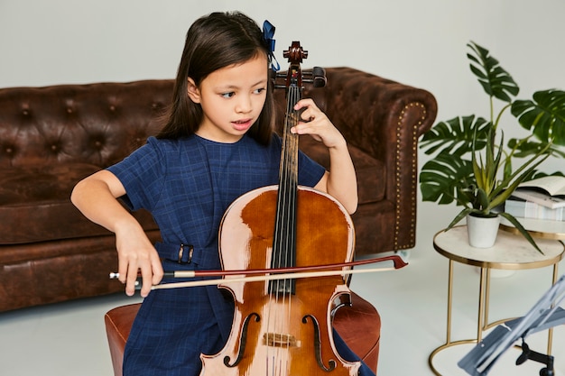 Meisje dat thuis cello leert spelen