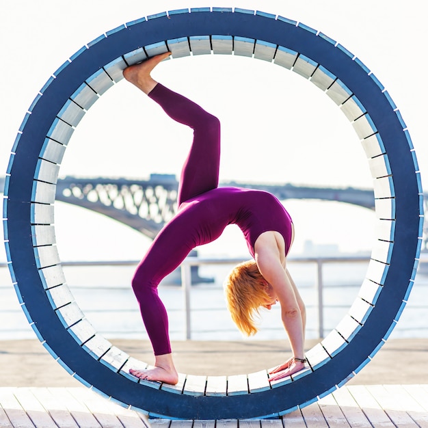 Meisje dat yoga in een ring op het strand doet