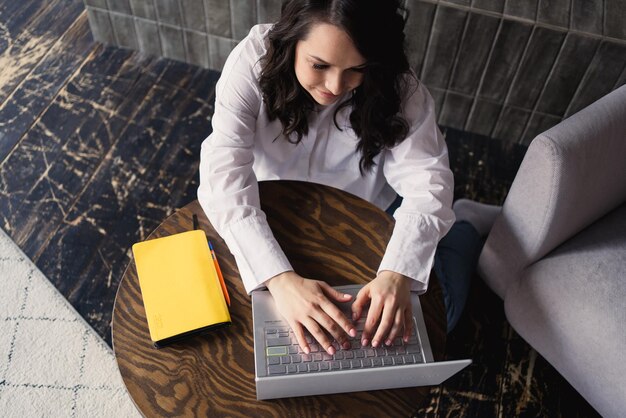 Meisje die aan laptop van huis werken of student die van huis of freelancer bestuderen