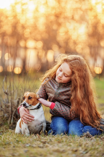 Meisje die haar vriend koesteren een hond in openlucht.